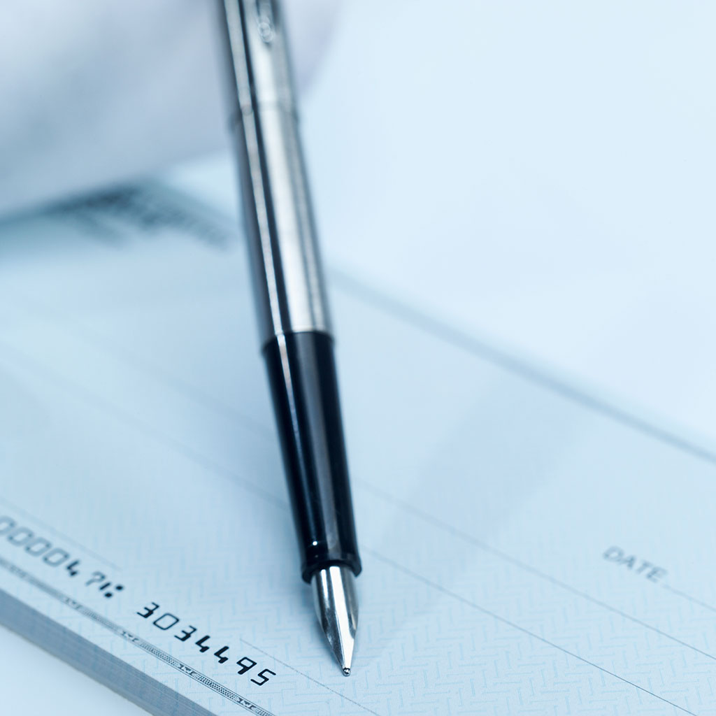 Photo depicting a pen lying on top of a check book.